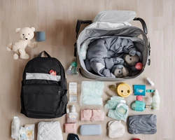 Een platliggende foto toont een verzameling babyartikelen en een luiertas. 