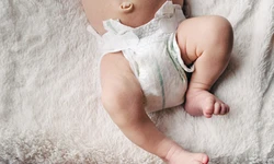 Baby met luier liggend in een box Baby met luier liggend in een box