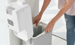 Luieremmer die open staan en er wordt een nieuwe zak in gedaan Luieremmer die open staan en er wordt een nieuwe zak in gedaan